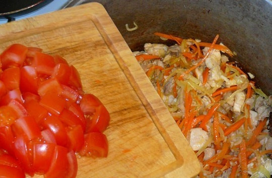 1. Этап. Каша рисовая со свининой: Томаты помойте. Если вы не хотите, чтобы в блюде были шкурки помидоров, то заранее очистите их. Для этого вскипятите воду и опустите в кипяток томаты на несколько минут. Тогда кожица с них слезет очень легко и быстро. Нарежьте помидоры дольками и отправьте в казанок.