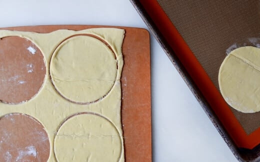 1. Этап. Яичница на слоеном тесте: 1. Слоеное тесто раскатайте тонко, специальной формочкой или стаканом вырежьте 4 круга и переложите их на противень.