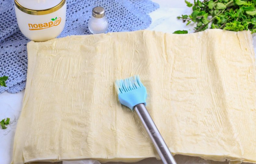 1. Этап. Болгарская баница: Отделите два листа теста и смажьте их сливочным маслом по всему периметру.