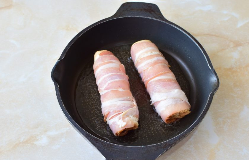 1. Этап. Рулеты с беконом: На горячую сковороду налейте немного растительного масла и обжарьте рулетики со всех сторон.