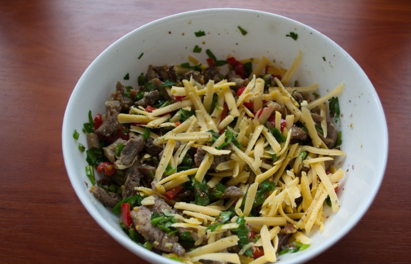 1. Этап. Салат с говядиной и сыром: Добавляем грецкий орех и натертый на терку твердый сыр. Заправляем салат маслом. Добавляем соль и перец.