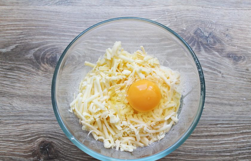 1. Этап. Сырные булочки без дрожжей: Вбейте в миску с сыром и мукой яйцо.