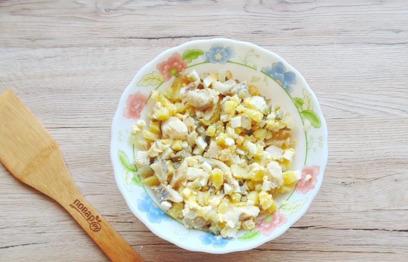 1. Этап. Салат с рыбой без майонеза: Репчатый лук очистите, помойте и нарежьте произвольно. Обдайте кипятком, чтобы уменьшить горечь и выложите в салат. Посолите, поперчите и заправьте растительным маслом.