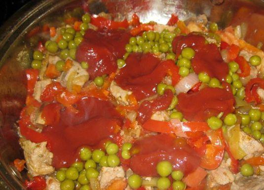 1. Этап. Свинина с болгарским перцем: Затем сбавляем огонь и добавляем в сковороду томатную пасту, консервированный горошек и кубиками нарезанные помидоры.