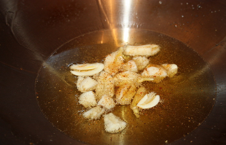 1. Этап. Креветки жареные в панцире: Прогрейте вок, затем налейте в него масло, и, когда оно прогреется, выложите в вок чеснок, нарезанный дольками. Добавьте специи по вкусу.