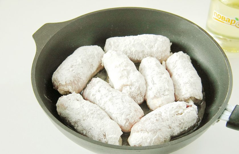1. Этап. Мясные рулетики с луком: Сверните все отбивные с начинкой рулетиком и обваляйте со всех сторон в муке. Разогрейте на сковороде масло и выложите получившиеся рулетики.