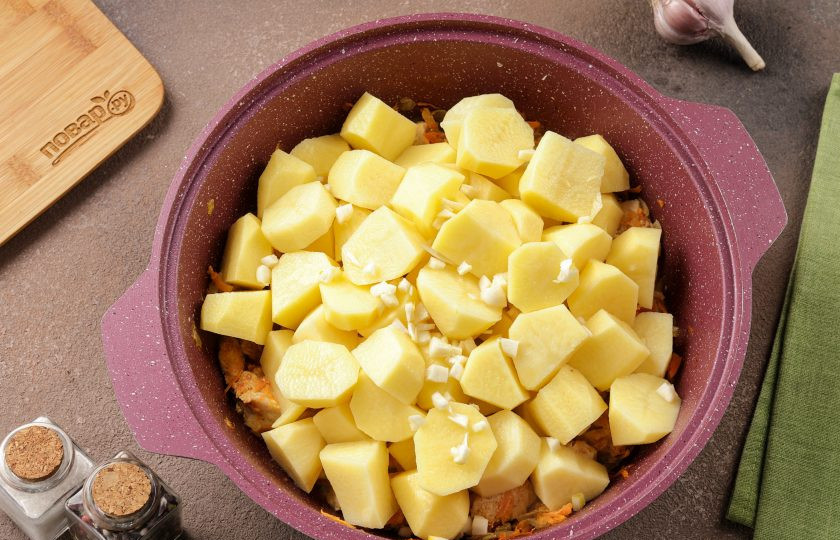 1. Этап. Курица с картофелем и морковью: Затем добавьте нарезанный кусочками картофель и нарезанный мелкими кубиками чеснок.