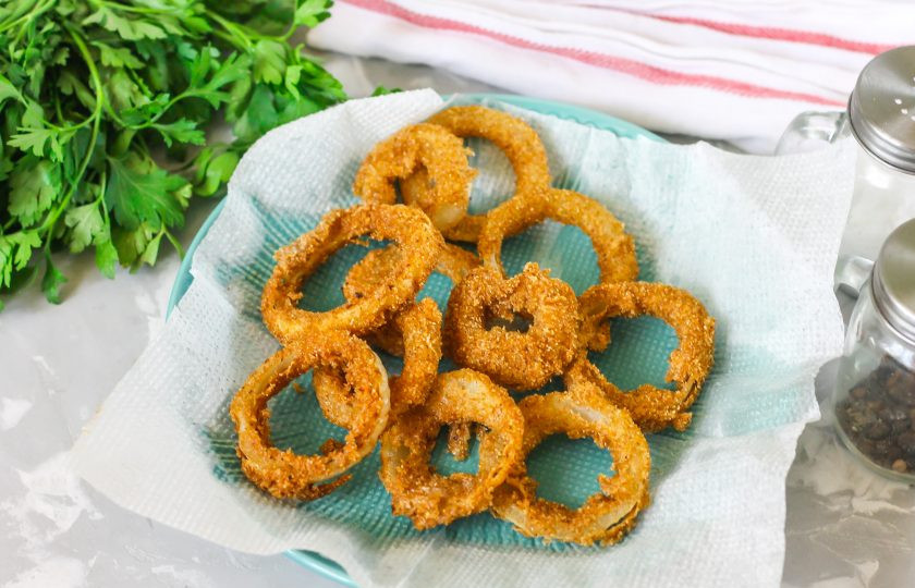 1. Этап. Хрустящий жареный лук: Застелите бумажными салфетками тарелку и выложите жареные кольца на них с помощью шумовки, чтобы удалить лишний жир.