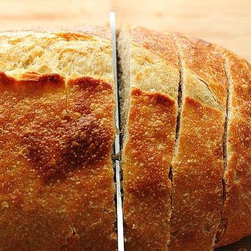 1. Этап. Хлеб с артишоками, сыром и чесноком: 5. Нарезать хлеб ломтиками толщиной 2,5 см, не доходя до конца буханки.