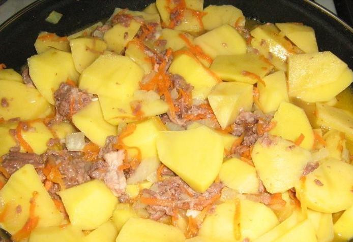 1. Этап. Картошка с тушенкой: Далее содержимое сковороды необходимо залить водой, чтоб все покрыло водой. Добавить лавровый лист, поперчить, посолить, добавить специи по вкусу и накрыть крышкой. Томить блюдо на среднем огне около 30 минут, иногда перемешивая.