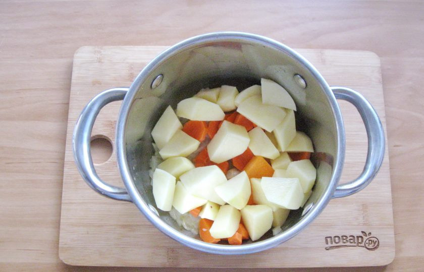 1. Этап. Тыквенный суп с мясом краба: Картофель и морковь очистите и помойте, нарежьте кубиками. Добавьте в кастрюлю.