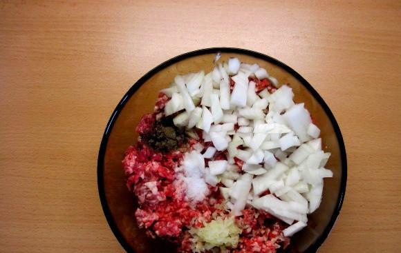 1. Этап. Мясная запеканка с картофелем: 5. Чеснок очистить и выдавить через пресс. К фаршу необходимо добавить лук, соль и перец по вкусу и чеснок. Тщательно перемешать.