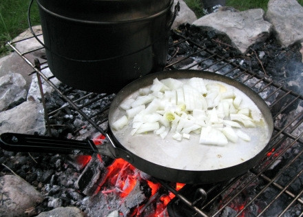 1. Этап. Уха на природе: Лук, нарезанный кубиками, обжарьте в масле до золотистого цвета.