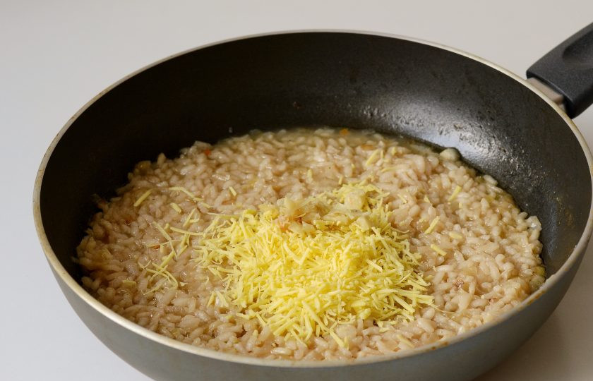 1. Этап. Ризотто Джейми Оливера: Выдавите чеснок из кожуры, добавьте в ризотто. Перемешайте. Снимите сковороду с плиты, добавьте сыр и сливочное масло. Перемешайте и оставьте под крышкой на 5 минут.