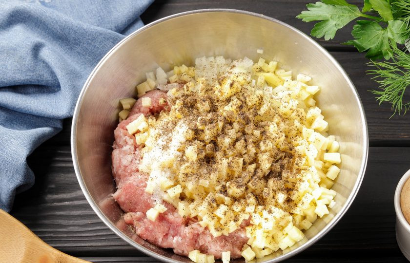 1. Этап. Беляши из дрожжевого теста в духовке: Пока поднимается тесто, приготовьте начинку. В фарш добавьте нарезанный мелкими кубиками лук и картофель. Добавьте соль и специи по вкусу.