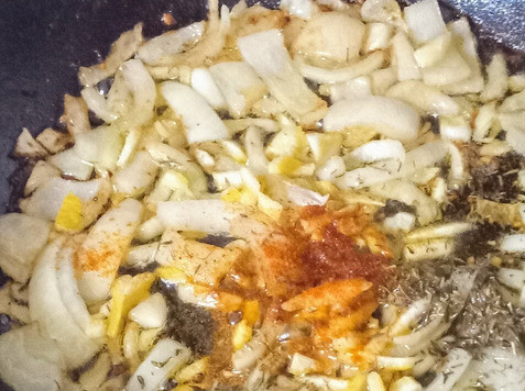 1. Этап. Капуста савойская с нутом и пармезаном: На дне того же казана разогреть оставшееся оливковое масло, выложить лук и чеснок. Тушить на медленном огне 5 минут до размягчения. Затем добавить тимьян, перец красный жгучий и цедру лимона. Готовить 1 минуту до появления аромата.