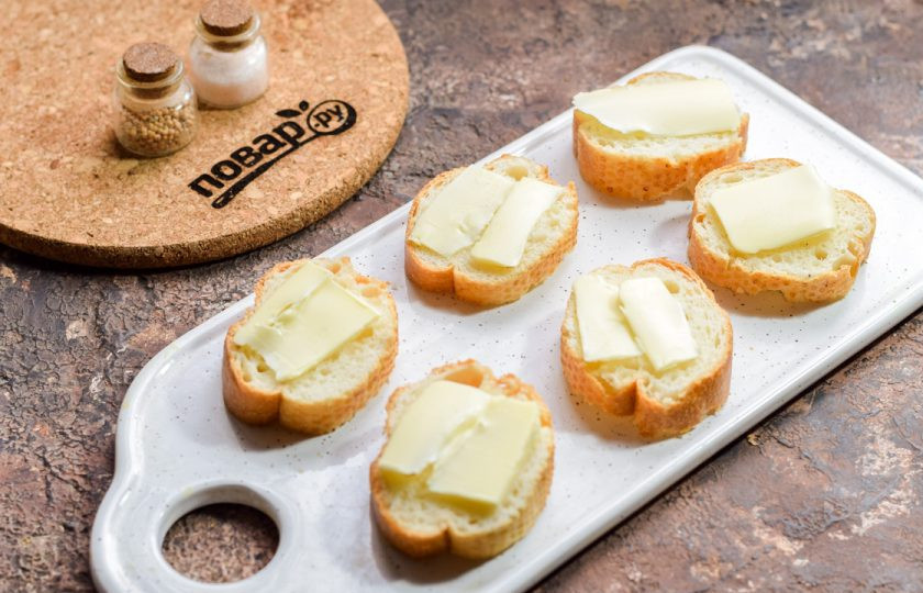 1. Этап. Бутерброды с селедкой и киви: Смажьте каждый кусочек багета сливочным маслом.