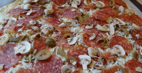 1. Этап. Пицца с колбасой и грибами: В небольшой миске смешать все ингредиенты для соуса (варить не надо), выложить на тесто. Сыр потереть на тёрке и посыпать сверху. Колбасу, грибы и оливки нарезать кружочками и разложить на пицце.