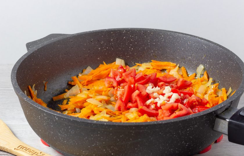 1. Этап. Поджарка из колбасы: Затем добавьте нарезанные томаты и рубленный чеснок. Жарьте ещё пару минут.