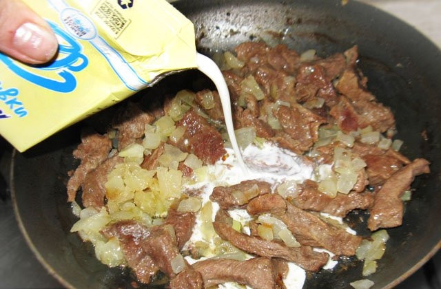 1. Этап. Говядина с макаронами: Спустя час верните на сковороду к говядине лук, влейте сливки и дайте им закипеть.