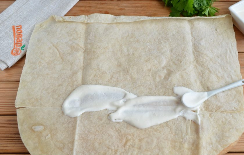 1. Этап. Фарш в лаваше по-провански: Прямоугольный лаваш расстелите на столе. Смажьте майонезом или сметаной, можно использовать кетчуп или томатный соус.