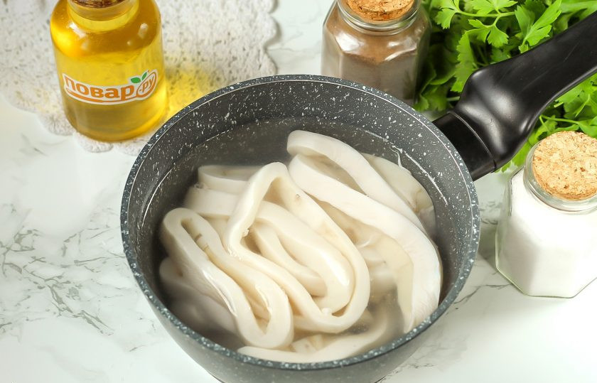 1. Этап. Вяленый кальмар: Вскипятите воду в ковше или сотейнике и выложите в нее кольца кальмаров.