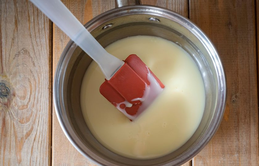 1. Этап. Конфеты из сгущённого молока и какао: Сгущенное молоко выложите в сотейник и поставьте на небольшой огонь. Постоянно помешивая лопаткой, дождитесь появления первых пузырьков закипания. Снимите сотейник с плиты.