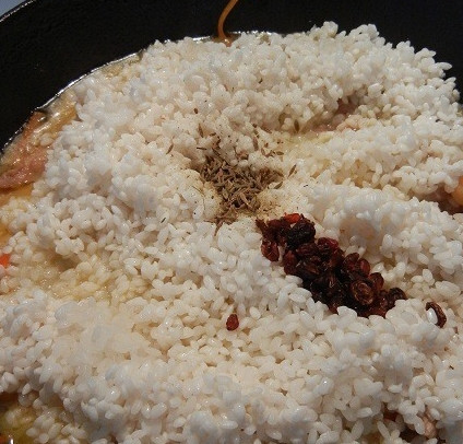 1. Этап. Плов таджикский: 5. Рис промойте под проточной водой и выложите в казанок. Посолите, поперчите, добавьте специи по вкусу.