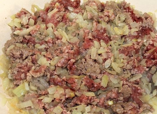 1. Этап. Маленькие пирожки с мясом: 1. Мясо вымыть, обсушить немного и пропустить через мясорубку. Очистить луковицу и нарезать мелкими кубиками. Пропустить через пресс или мясорубку очищенный чеснок. Разогреть сковороду с небольшим количеством растительного масла и выложить туда фарш с овощами. На среднем огне жарить около 10 минут.