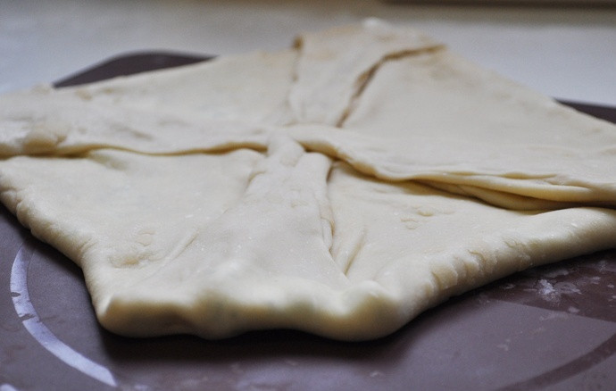 1. Этап. Тонкие лепешки с зеленью: Сверните лепешку тонко, вытяните концы и сверните их к центру.