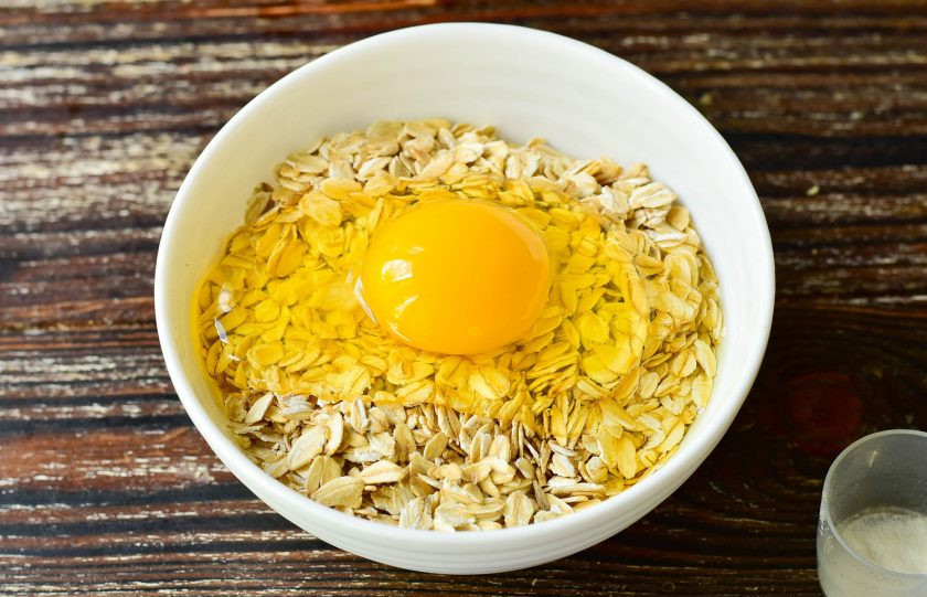 1. Этап. Маффины Фитнес: В миску к овсяным хлопьям вбейте куриное яйцо.