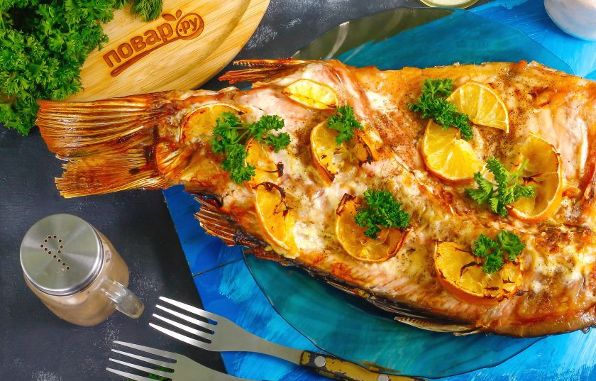 1. Этап. Сазан в духовке с лимоном: Украсьте запеченную рыбу свежей зеленью, по желанию — можете нарезать на части и подайте к столу горячей.