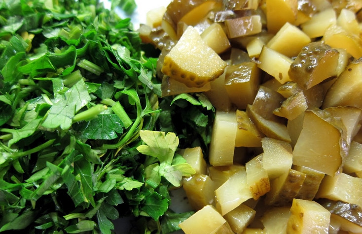 1. Этап. Солянка с маслинами: Зелень промойте и измельчите. Соленые огурцы порежьте небольшими ломтиками.