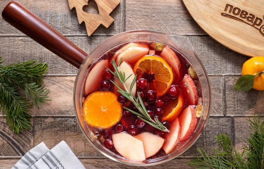 1. Этап. Глинтвейн новогодний: Добавьте нарезанные фрукты, веточку розмарина и клюкву. Доведите почти до кипения на небольшом огне, чтобы появились первые пузырьки. Затем накройте крышкой и дайте настояться 10-12 минут.