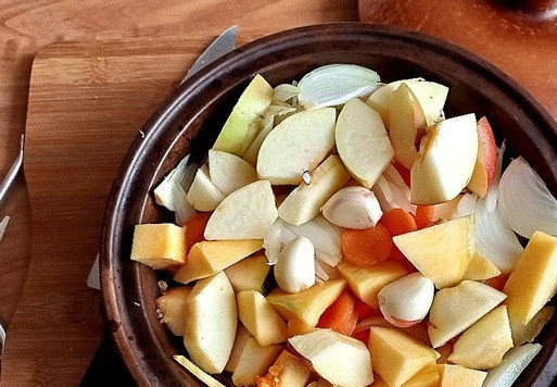 1. Этап. Овощное ассорти на кеци с колбасой: Я буду готовить на кеци. Кеци позволяет готовить сочные ароматные блюда с минимальным количеством жира. Таким же свойством обладают русская латка и болгарский сач. Используют кеци для готовки блюд на газовой или электрической плите, в духовке, на открытом огне, но блюда получатся вкуснее, если готовить на углях. Чтобы дольше сохранить блюдо горячим, его подают прямо в кеци. Моя кеци D-22 см и высотой -5 см. Все овощи и яблоко режем произвольно и не мельчим. Лук я порезала перьями, чеснок оставила зубчиками.