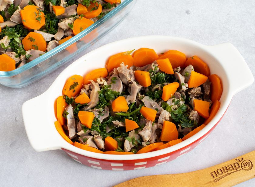 1. Этап. Заливное из куриных желудков: С помощью шумовки достаньте овощи и желудки. Бульон процедите. Желудки нарежьте частями, а морковь кружочками. Разложите всё в емкости и при желании добавьте немного зелени.