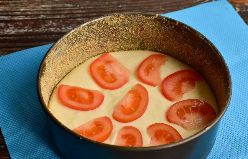 1. Этап. Заливной пирог с помидорами и сыром: Выложите на тесто кусочки помидора.