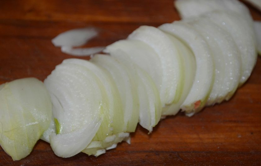 1. Этап. Подлива мясная: Обычный репчатый лук очистите от шелухи, вымойте его и обсушите. Луковица должна быть довольно крупной. Нарежьте лук полукольцами и отправьте его обжариваться в сковороду к мясу.