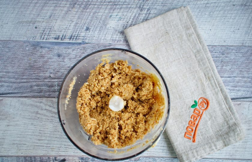 1. Этап. Кокосовый чизкейк: Печенье поломайте, сложите в чашу блендера, добавьте размягченное сливочное масло. Пробейте до мелкой крошки.