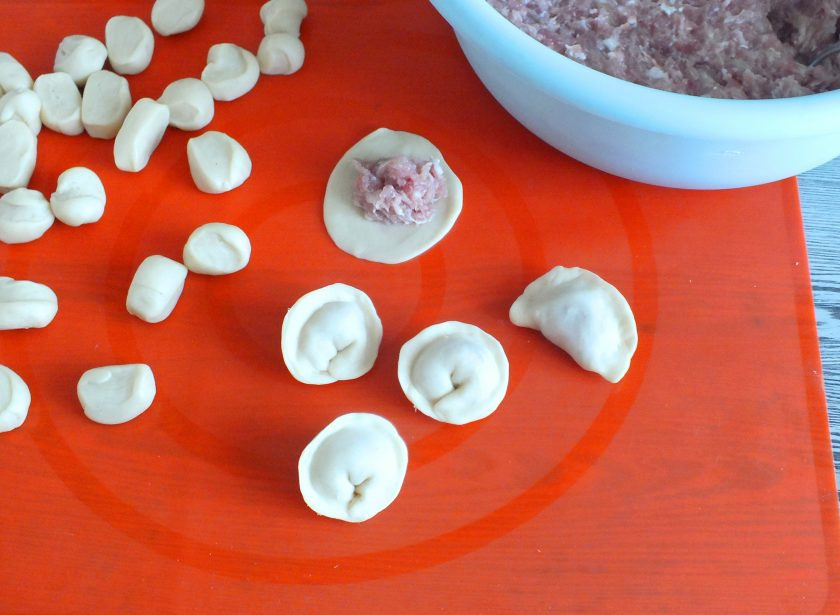 1. Этап. Пельмени из трёх видов мяса: На каждую лепешечку выложите фарш. Он слегка имеет мажущую консистенцию, поэтому его удобней накладывать вилкой. Сформуйте пельмени. Готовые пельмени можно отварить сразу, а можно часть заморозить.