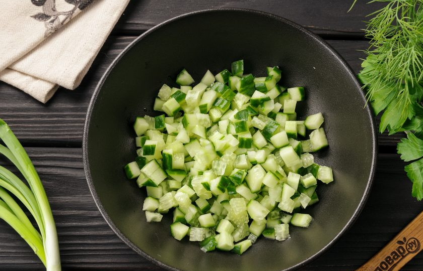 1. Этап. Салат с тунцом, кукурузой и сыром: Огурец нарежьте кубиками и выложите в глубокую миску.