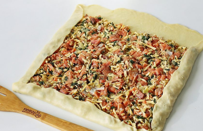 1. Этап. Штрудель с рыбой: Посыпьте тесто сухарями и сверху распределите равномерно начинку, немного отступив от одного края. Затем подверните края с трех сторон как на фото, и сверните плотный рулет.