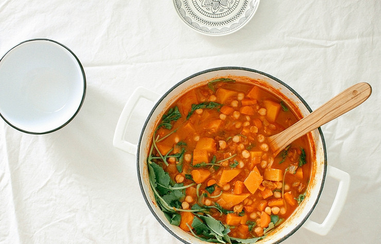 1. Этап. Рагу с нутом и тыквой: 4. В кастрюле разогрейте столовую ложку растительного масла, добавьте лук, спустя 5 минут выложите чеснок, имбирь, все специи. Через 1 минуту добавьте морковь, картофель, тыкву, нарезанные кусочками томаты, нут, изюм, влейте бульон. Тушите блюдо на слабом огне в течение 40 минут после закипания. Добавьте листья шпината и готовьте еще пару минут.