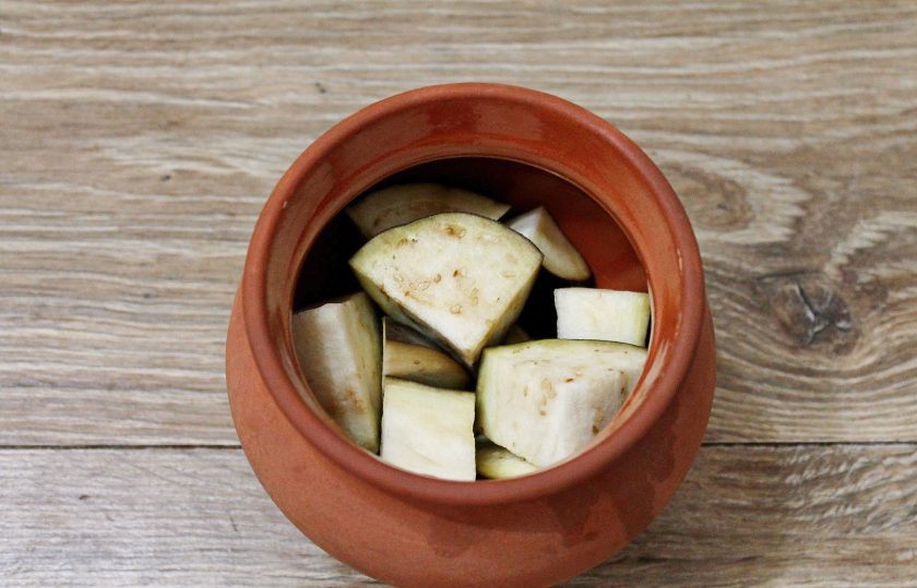 1. Этап. Мясо с баклажанами в горшочках в духовке: В горшочки выложите кусочки баклажанов, посолите и перемешайте.