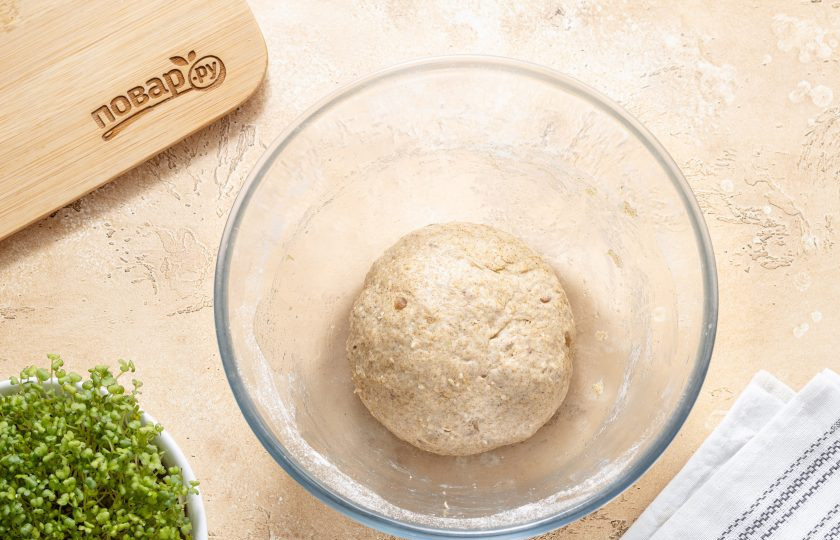 1. Этап. Ржаные булочки с отрубями: Замесите однородное тесто. Дополнительно лучше не подсыпать много муки, а смазать тесто растительным маслом, чтобы оно не липло к рукам. Сформируйте тесто в шар, переложите в миску и накройте полотенцем. Уберите в теплое место подниматься на 1,5 часа.