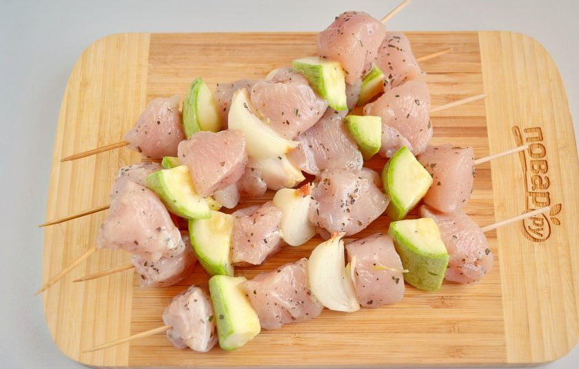 1. Этап. Куриный шашлык по-гречески с соусом: Маринованное мясо с овощами нанизывайте на бамбуковые шпажки, чередуя, и не слишком плотно друг к другу.