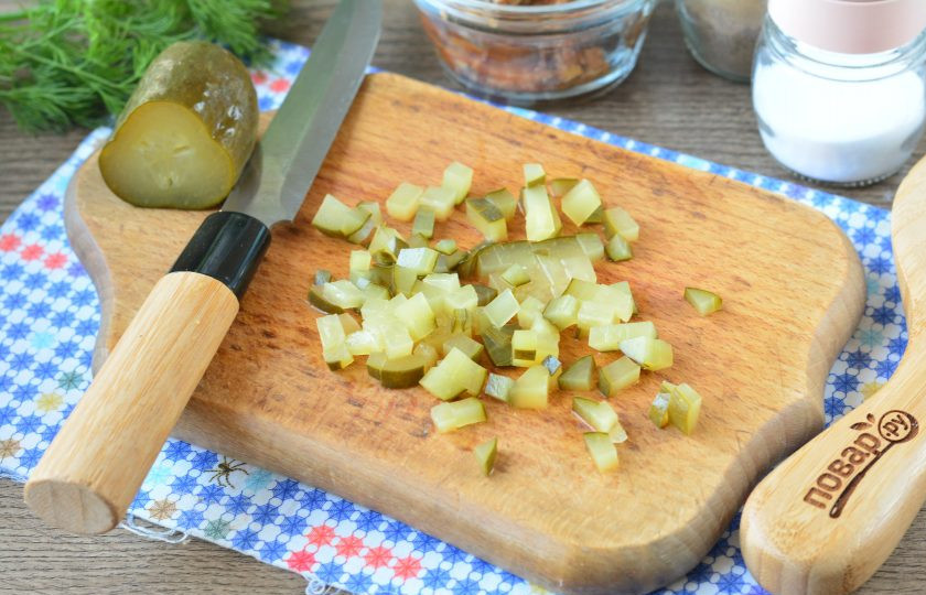 1. Этап. Яйца фаршированные килькой: Нарежьте мелкими кубиками соленые огурцы.