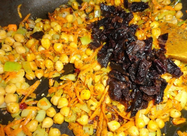 1. Этап. Плов с черносливом: Когда овощи станут мягкими, добавляем полуготовый нут и чернослив, обжариваем все вместе еще три минуты, а затем всыпаем сушеную зелень, перемешиваем.