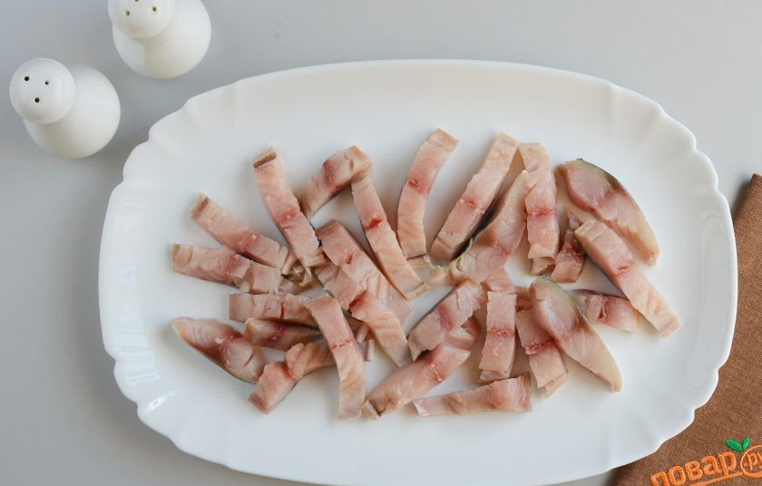 1. Этап. Салат со скумбрией: Порежьте скумбрию полосочками, выложите на сервировочное блюдо.