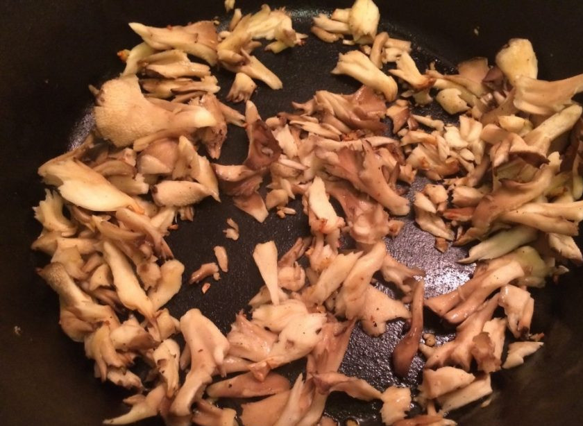 1. Этап. Паппарделле из кабачков: 3. Очистите оставшийся зубчик чеснока и измельчите его. Вымойте грибы и нарежьте их крупно. Разогрейте сковороду с растительным маслом и добавьте чеснок, затем грибы, обжаривайте пару минут.